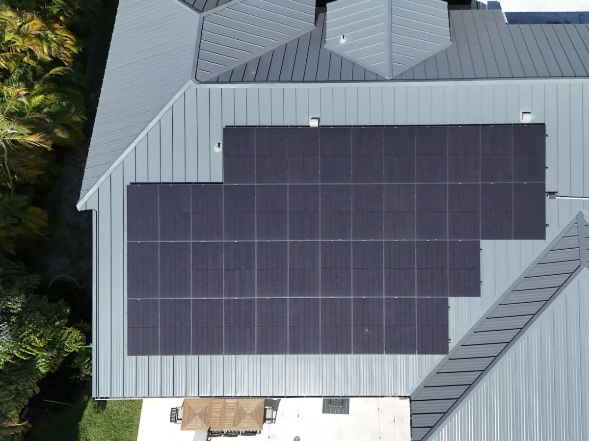 Full rooftop solar array on a grey metal roof
