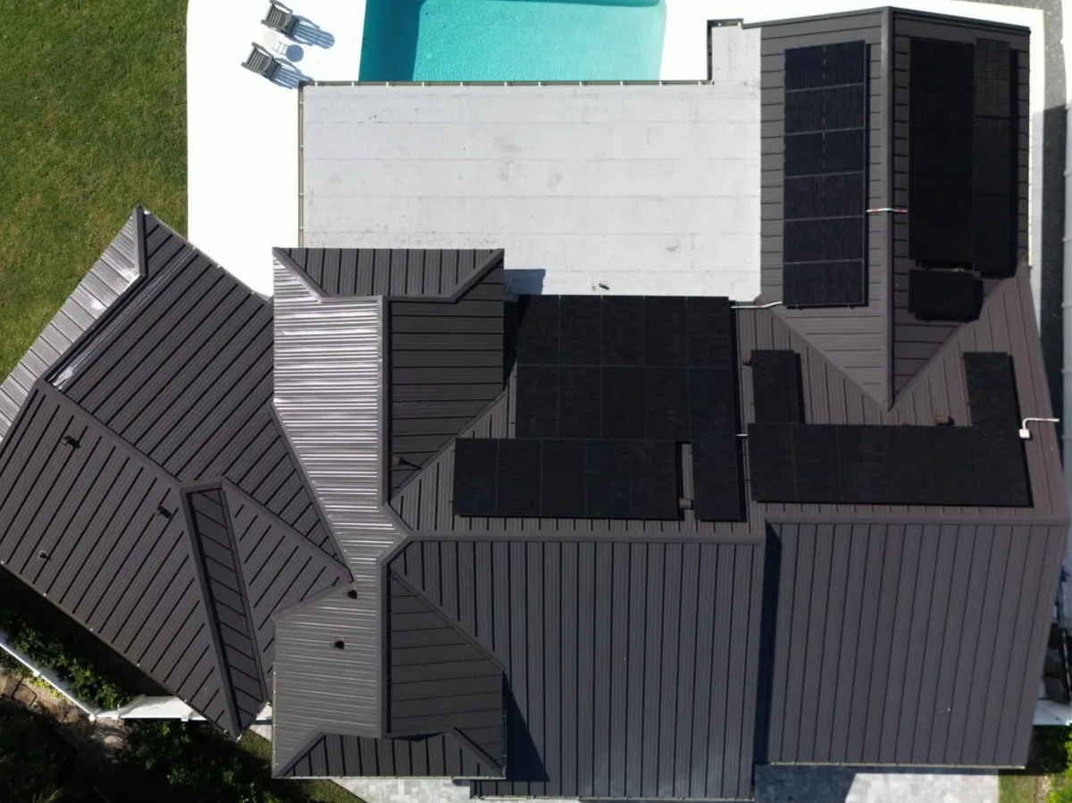 Solar array spanning multiple roof planes on a dark metal roof